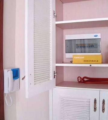 老電工把配電箱安裝在墻內(nèi)。曬太陽(yáng)太聰明了。